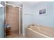 Bathroom featuring a soaking tub, tiled walk-in shower, and neutral toned walls at 50 Meredith Dr # 9, Englewood, FL 34223