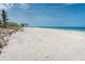 Wide, sandy beach with clear water and a view of nearby building and blue skies at 50 Meredith Dr # 9, Englewood, FL 34223