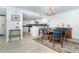 Dining room with elegant chandelier and adjacent kitchen with white cabinets and blue backsplash at 50 Meredith Dr # 9, Englewood, FL 34223