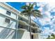 Condominium exterior with private balconies, tropical foliage, and beautiful blue sky at 50 Meredith Dr # 9, Englewood, FL 34223
