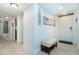 Bright hallway featuring tile flooring, decorative mirrors, and access to the bathroom at 50 Meredith Dr # 9, Englewood, FL 34223