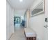 Well lit hallway featuring a decorative bench and leading to the living area with a glimpse of the balcony at 50 Meredith Dr # 9, Englewood, FL 34223