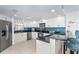 Modern kitchen with white cabinets, stainless steel appliances, and a striking blue backsplash at 50 Meredith Dr # 9, Englewood, FL 34223