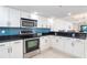 Modern kitchen features white cabinetry, stainless steel appliances, black countertops, and a vibrant blue backsplash at 50 Meredith Dr # 9, Englewood, FL 34223