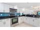 Modern kitchen features white cabinets, stainless steel appliances, and black granite countertops at 50 Meredith Dr # 9, Englewood, FL 34223