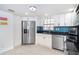 Bright kitchen featuring stainless steel appliances, white cabinetry, and a stylish blue tile backsplash at 50 Meredith Dr # 9, Englewood, FL 34223