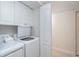 Bright laundry area features a washer, dryer, storage cabinets, and a door to another room at 50 Meredith Dr # 9, Englewood, FL 34223