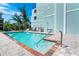 Community pool with a brick paver deck and partial view of the building's exterior at 50 Meredith Dr # 9, Englewood, FL 34223