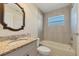 Bright bathroom features granite countertop, stylish mirror, and a combined tub and shower at 5781 Elton Rd, Venice, FL 34293