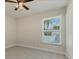 Bright bedroom featuring a ceiling fan, tiled floors, and a window providing natural light at 5781 Elton Rd, Venice, FL 34293