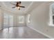 Spacious bedroom with tray ceiling, ceiling fan, and sliding glass doors to the patio at 5781 Elton Rd, Venice, FL 34293