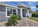 Close-up of a home's entrance featuring white pillars, brick walkway and well-maintained landscaping at 5781 Elton Rd, Venice, FL 34293