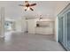 Spacious open-concept living area with tiled floors, ceiling fan, and view of the kitchen and sliding door at 5781 Elton Rd, Venice, FL 34293