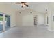 Open-concept living space with tile floors, sliding glass door, ceiling fan and neutral color palette at 5781 Elton Rd, Venice, FL 34293