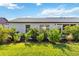 Well-maintained backyard with mature landscaping, a patio, and green grass at 609 Deerwood Ave, Englewood, FL 34223