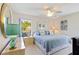Bright bedroom with a blue comforter, a window view, lamps, and a ceiling fan at 609 Deerwood Ave, Englewood, FL 34223