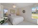 Bright bedroom featuring a queen bed with white linens, soft decor, and a ceiling fan at 609 Deerwood Ave, Englewood, FL 34223