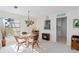 Dining room with natural light, a glass-top table and seating for four adjacent to the pass through kitchen at 609 Deerwood Ave, Englewood, FL 34223