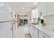 Bright kitchen with white cabinets and marble countertops, flowing to an outdoor seating area at 609 Deerwood Ave, Englewood, FL 34223