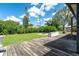 A spacious backyard features a wooden deck, lush green grass, and plenty of foliage at 7059 Quigley St, Englewood, FL 34224