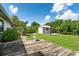 Spacious backyard with a wooden deck, a shed, and mature landscaping at 7059 Quigley St, Englewood, FL 34224