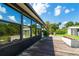 Backyard featuring a wooden deck, glass windows, and a lush green yard with mature trees at 7059 Quigley St, Englewood, FL 34224