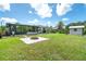 A spacious backyard features lush grass, a brick fire pit, and a tool shed at 7059 Quigley St, Englewood, FL 34224
