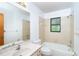 A standard bathroom with a shower-tub combo, toilet, large mirror and vanity sink at 7059 Quigley St, Englewood, FL 34224