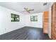 Bright bedroom with dark gray wood flooring, white walls, and a ceiling fan at 7059 Quigley St, Englewood, FL 34224