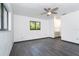 Bright bedroom with gray wood flooring, white walls, and views of the adjacent bathroom at 7059 Quigley St, Englewood, FL 34224