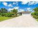 Well-maintained single-story home featuring an attached two-car garage and mature landscaping along the driveway at 7059 Quigley St, Englewood, FL 34224