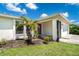 Inviting front entrance with a screened-in porch, beautiful landscaping, and attached single car garage at 7059 Quigley St, Englewood, FL 34224