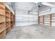 A spacious garage with a white door and lots of shelving for storage at 7059 Quigley St, Englewood, FL 34224