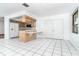 Open kitchen area featuring light wood cabinets, white tile floors, and built-in breakfast bar at 7059 Quigley St, Englewood, FL 34224