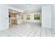 Kitchen featuring white tile flooring, wood cabinetry, and views of the tropical landscaping at 7059 Quigley St, Englewood, FL 34224