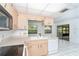 Traditional kitchen with light wood cabinets, white appliances, and view to adjoining living area at 7059 Quigley St, Englewood, FL 34224