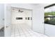 Bright, airy living room with white tile flooring, a ceiling fan, and access to outdoors at 7059 Quigley St, Englewood, FL 34224