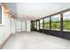 Enclosed porch with concrete flooring, dark framed screens, and access to outdoors at 7059 Quigley St, Englewood, FL 34224
