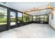 Covered porch with concrete flooring, dark screens, and access to the backyard at 7059 Quigley St, Englewood, FL 34224