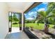 View from screened porch to the manicured lawn and tropical landscaping that surround the property at 7059 Quigley St, Englewood, FL 34224