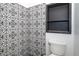 Updated toilet room features modern tile, built-in shelf, and a toilet at 7059 Quigley St, Englewood, FL 34224