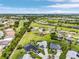 Wide aerial shot of the house, pool, and neighborhood, highlighting the lush green surroundings at 7130 Scarlet Sage Ct, Punta Gorda, FL 33955