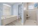 Elegant bathroom featuring a soaking tub, walk-in shower, and natural light at 7130 Scarlet Sage Ct, Punta Gorda, FL 33955