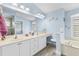 Well-lit bathroom with double vanity, a soaking tub, and a separate walk-in shower at 7130 Scarlet Sage Ct, Punta Gorda, FL 33955