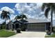 Charming single-story home with a well-manicured lawn, mature palm trees, and a two-car garage at 7130 Scarlet Sage Ct, Punta Gorda, FL 33955