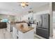 Modern kitchen with stainless steel appliances, a kitchen island with granite countertops, and pendant lighting at 7130 Scarlet Sage Ct, Punta Gorda, FL 33955
