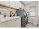 Laundry room with front-loading washer and dryer, a utility sink, and white cabinets at 7130 Scarlet Sage Ct, Punta Gorda, FL 33955