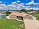 Aerial view of a home featuring a lush front lawn, driveway, and attached two-car garage at 7218 Darlington St, Englewood, FL 34224