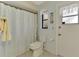 Cozy bathroom features a toilet, tiled floor, and a shower with a curtain at 7218 Darlington St, Englewood, FL 34224