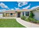 Charming single-story home with a well-manicured front yard, walkway, and beautiful landscaping at 7218 Darlington St, Englewood, FL 34224